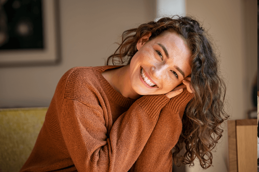 Woman in sweater smiling looking directly at camera