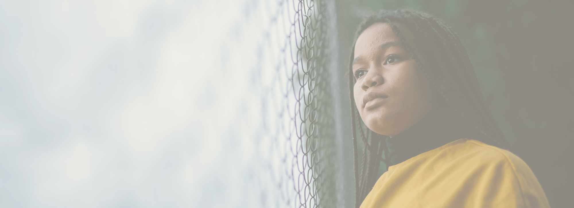 Young girl looking through fence. Cooperative Recovery opioid addiction treatment center.